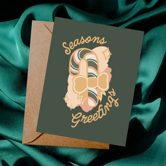 Greeting card and envelope with candy cane illustration and 'Season's Greetings' text on a dark background.