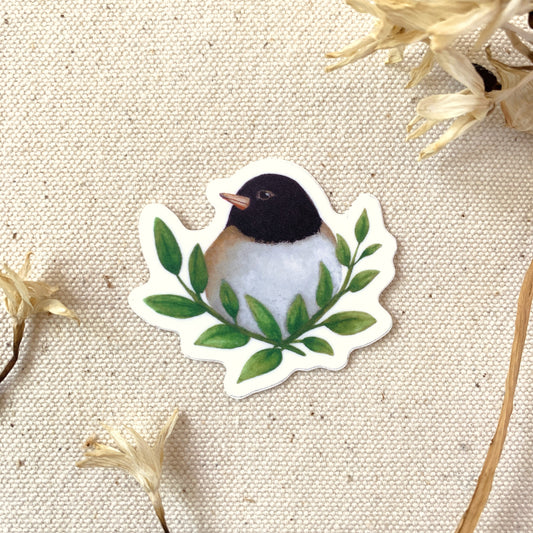 Sticker of a small bird with green leaves on a textured beige background