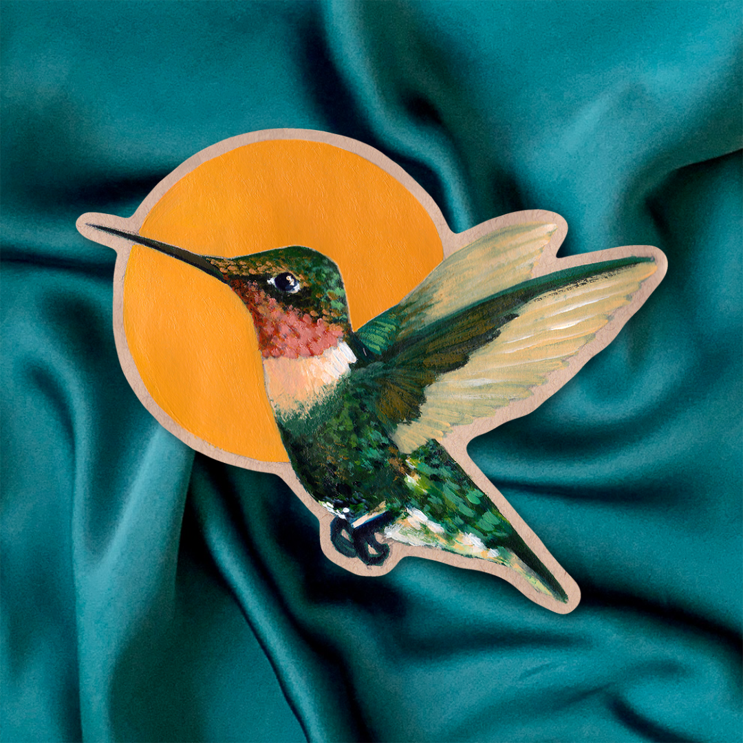 Sticker of a ruby-throated hummingbird on a teal fabric background.