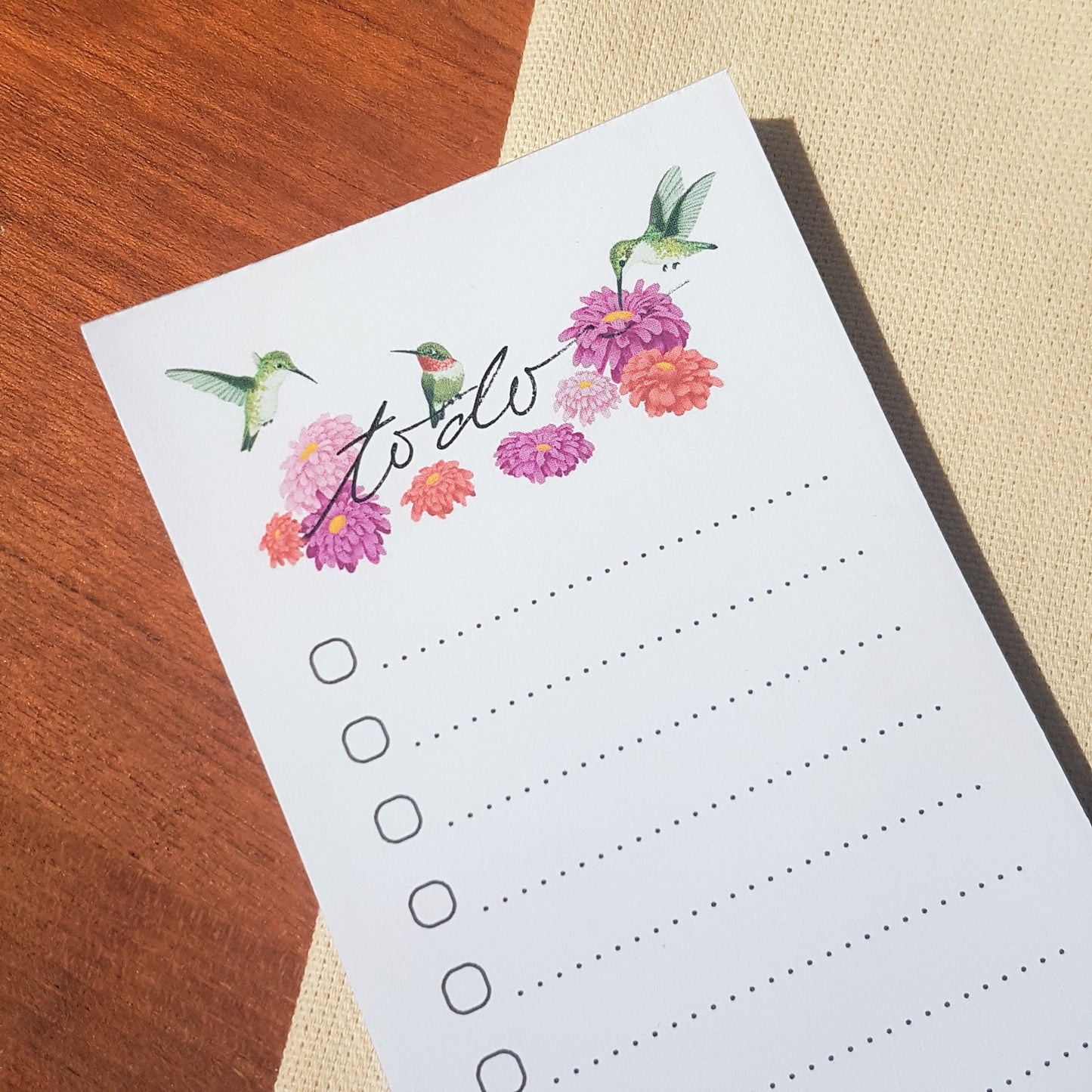Close up of Hummingbirds and flowers illustration on a to do list notepad.