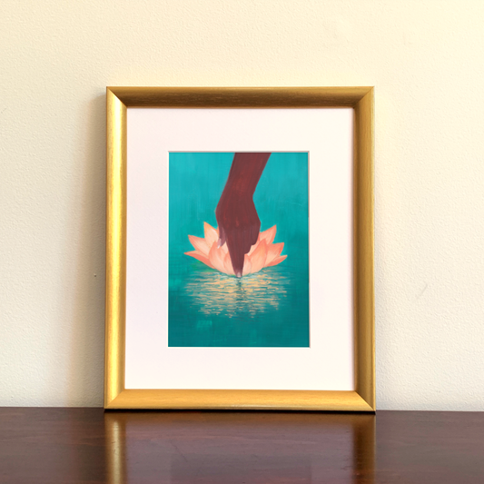 Framed artwork of a hand and lotus flower on a teal background.