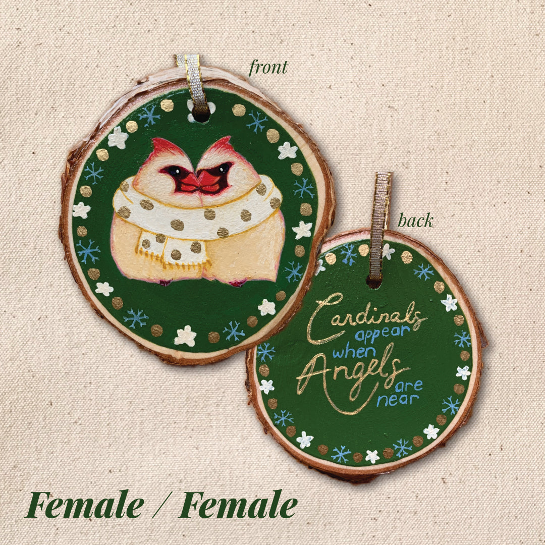 Decorative wooden ornament with cardinal design and text "Cardinals appear when angels are near" on a textured beige background.