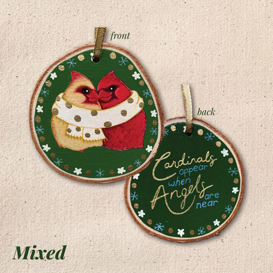 Decorative ornament with cardinal design and text "Cardinals appear when angels are near" on a textured beige background.