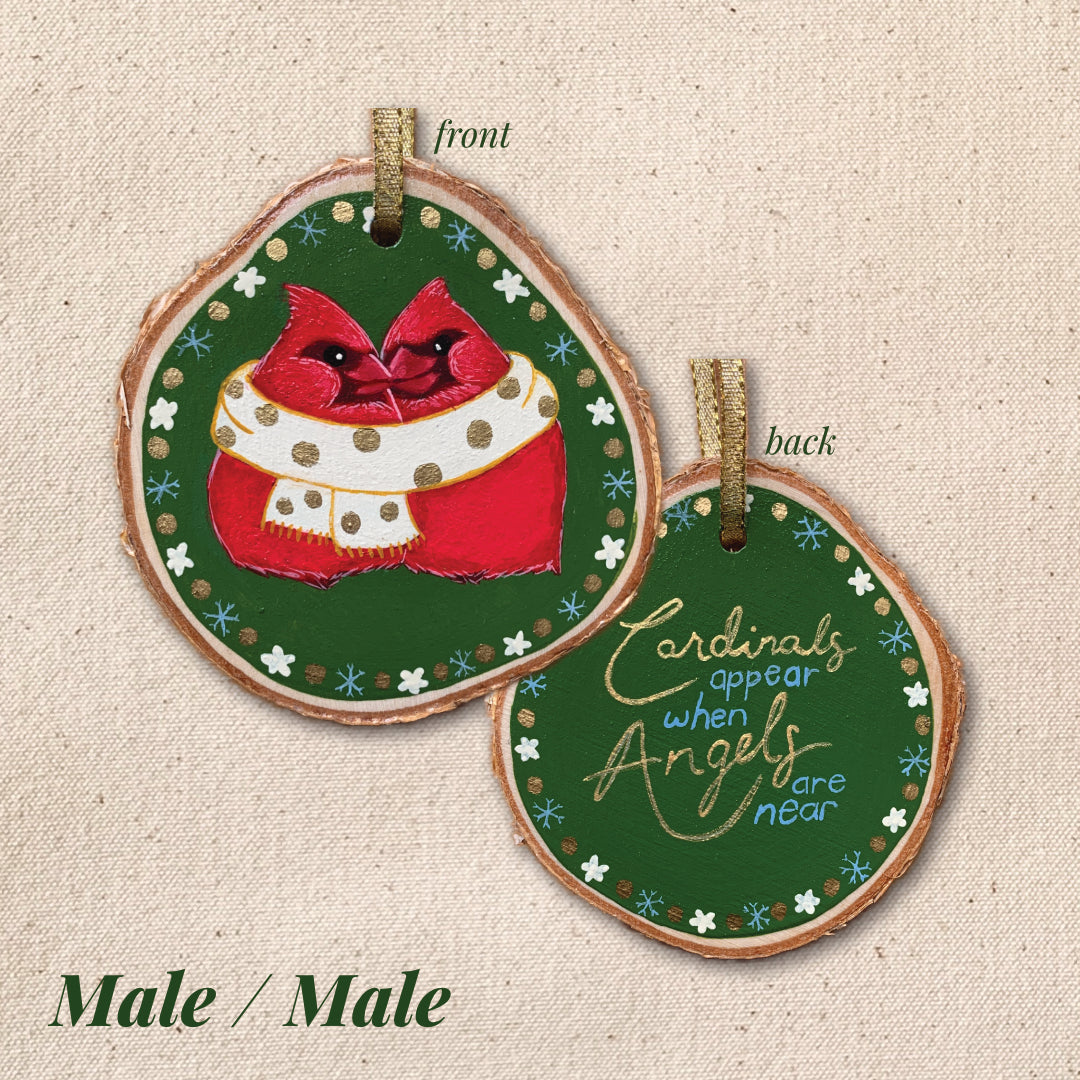 Decorative ornament with cardinal design and text "Cardinals appear when angels are near" on a textured beige background.