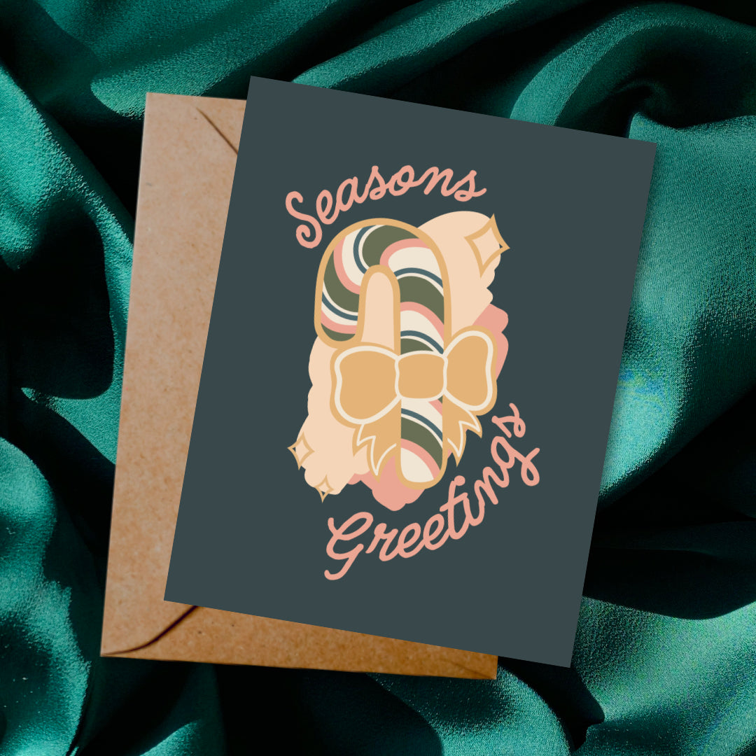 Greeting card and envelope with ornament illustration and 'Season's Greetings' text on a dark background.