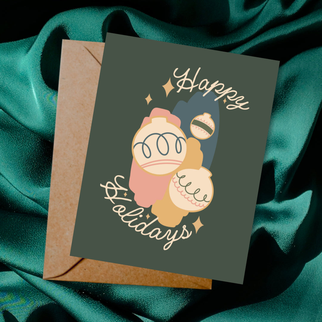 Greeting card and envelope with ornament illustration and 'Happy Holidays' text on a dark background.