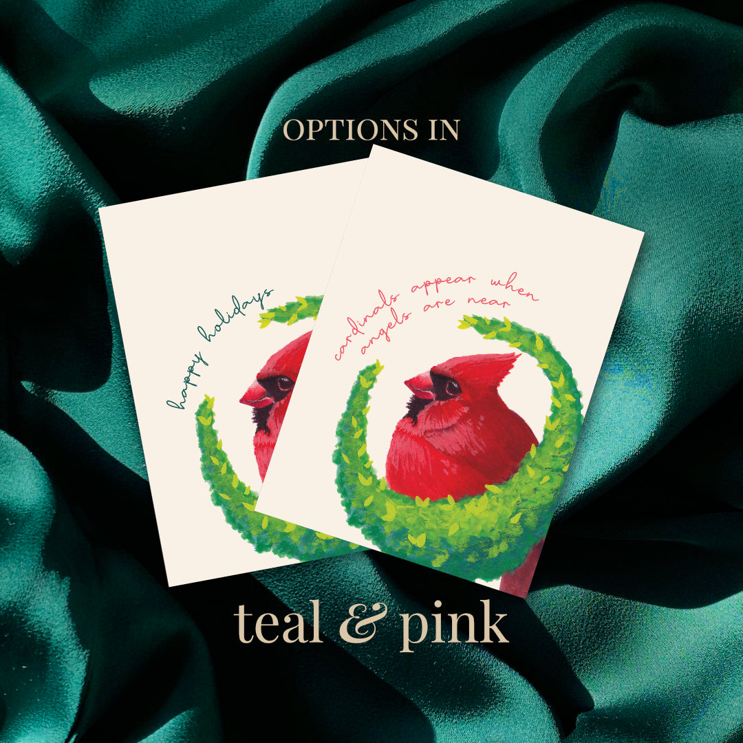 Two greeting cards with red cardinals on a teal fabric background, featuring text 'happy holidays' and 'cardinals appear when angels are near'.