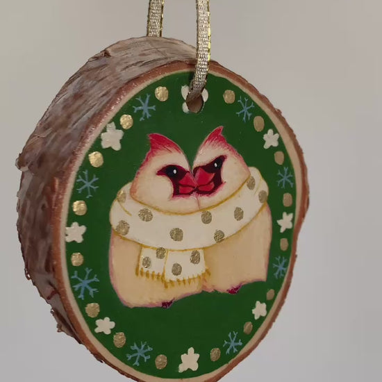 Three northern cardinal ornaments spin in space.