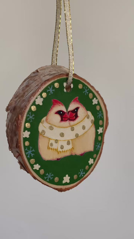 Three northern cardinal ornaments spin in space.